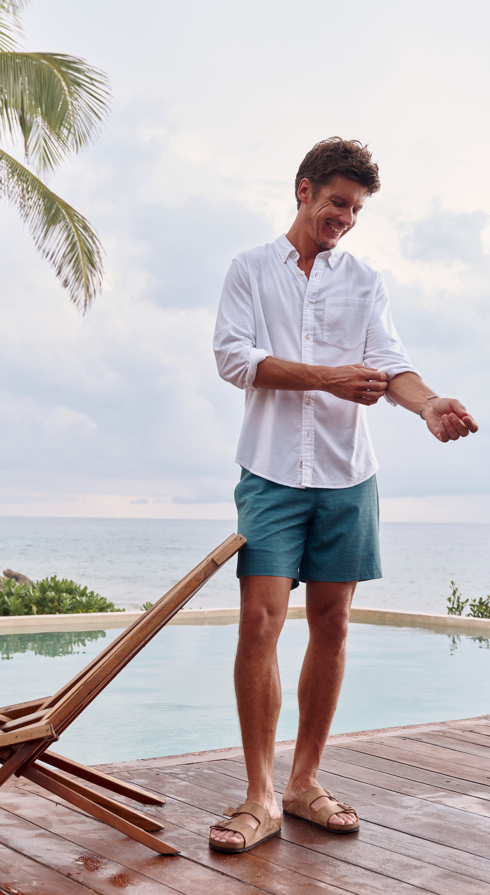 Man on beach wearing Whale Shark Tee and swim trunks